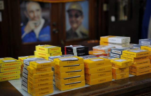 Posters of Cuban late president Fidel Castro and current president Raul Castro are seen behind boxes of cigars at the H.Upman Cigar Factory in Havana, on March 2, 2017. 