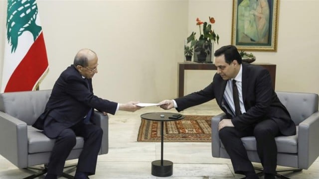 នាយករដ្ឋមន្រ្តីលីបង់ លោកHassan Diab (ខាងស្តាំ) ប្រគល់លិខិតការលាចេញពីតំណែងរបស់រដ្ឋាភិបាលឲ្យប្រធានាធិបតី លោក Michel Aoun។ រូបភាព៖ Reuters