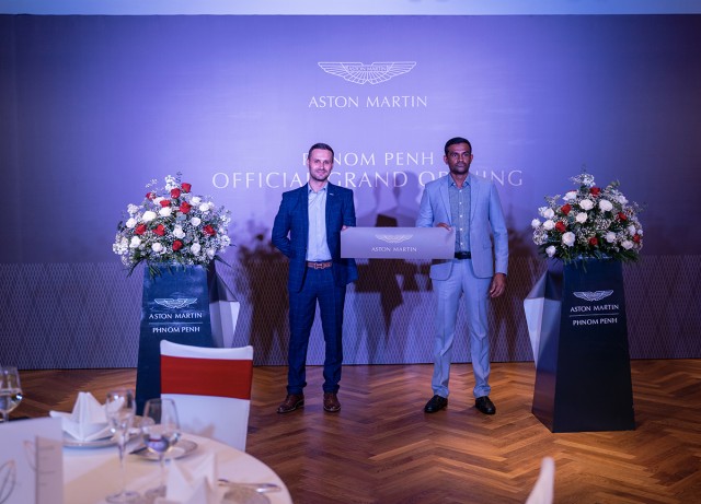 លោក Flavien Simon អ្នកគ្រប់គ្រងផ្នែកលក់ប្រចាំ Aston Martin Phnom Penh និងលោក Mr. Abarajithan Selvakumar ប្រធានផ្នែកហិរញ្ញវត្ថុនៃក្រុមហ៊ុន HGB Group ចូលរួមកាត់ខ្សែបូរពិធីសម្ពោធអគារបង្ហាញរថយន្ត Aston Martin Phnom Penh