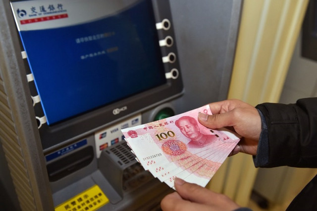 ប្រាក់យ័នដកពីទូ ATM មួយកន្លែងនៅប៉េកាំង ។ រូបភាព​ ៖ Xinhua 