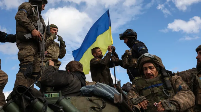 ទាហានអ៊ុយក្រែនកាន់ទង់ជាតិនៅលើរថពាសដែកក្នុងតំបន់ Donetsk ។ រូបភាព​ ៖ AFP 