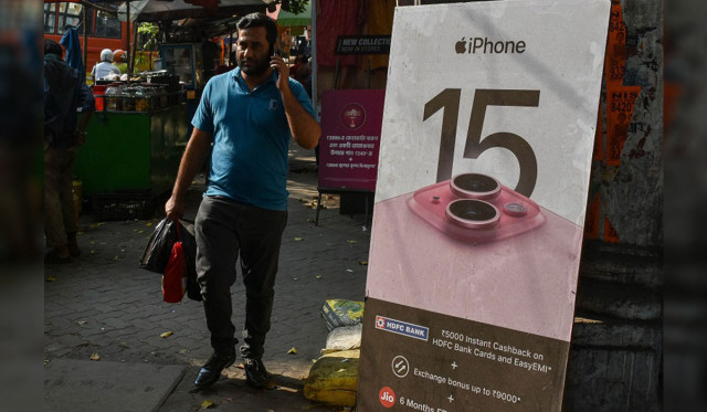បុរស​ម្នាក់​ដើរ​កាត់​ការ​ផ្សាយ​ពាណិជ្ជកម្ម Apple Iphone 15 នៅ​ទីក្រុង Kolkata ប្រទេស​ឥណ្ឌានៅ​ថ្ងៃទី៦ ខែវិច្ឆិកា ឆ្នាំ២០២៣។ រូបថត ៖ AFP
