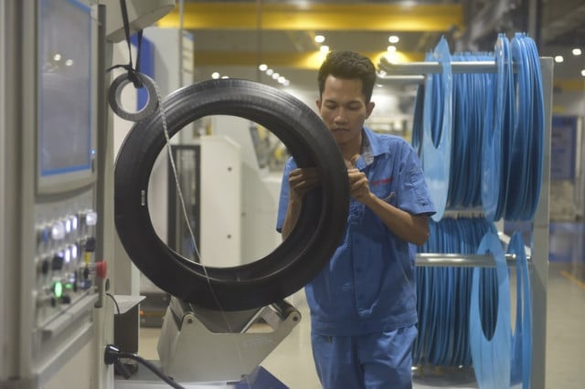កម្មករធ្វើការក្នុងរោងចក្រផលិតសំបកកង់ General Tire Technology ក្នុងតំបន់សេដ្ឋកិច្ចពិសេសក្រុងព្រះសីហនុ។ រូបភាព ៖ Xinhua